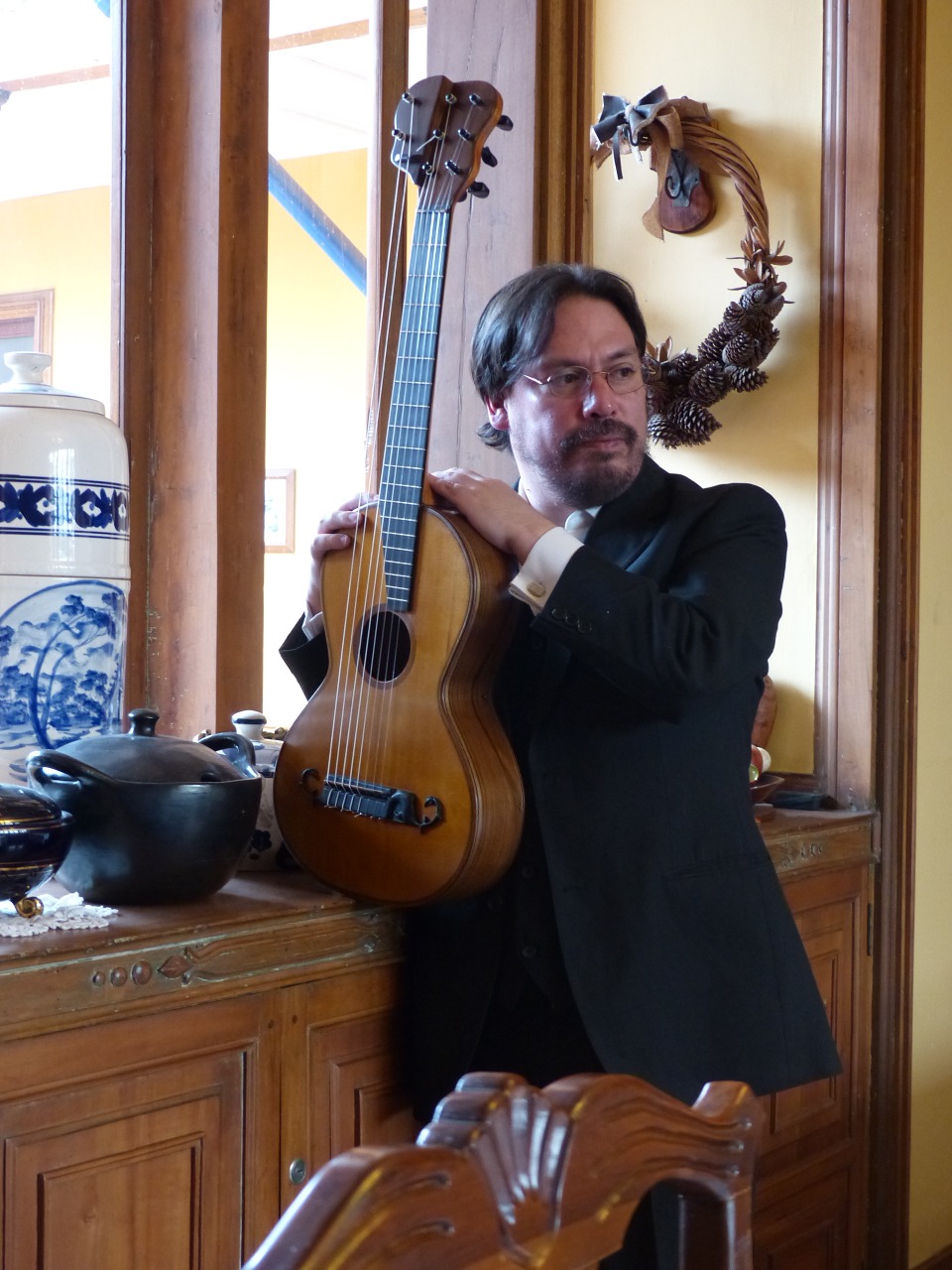 Retrato editorial de Andrés Zapico sosteniendo su guitarra en un interior